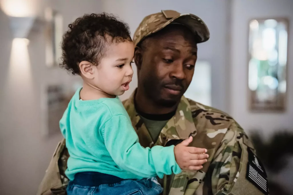 A military service member holding his son.