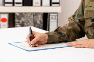 A military service member signing a document.