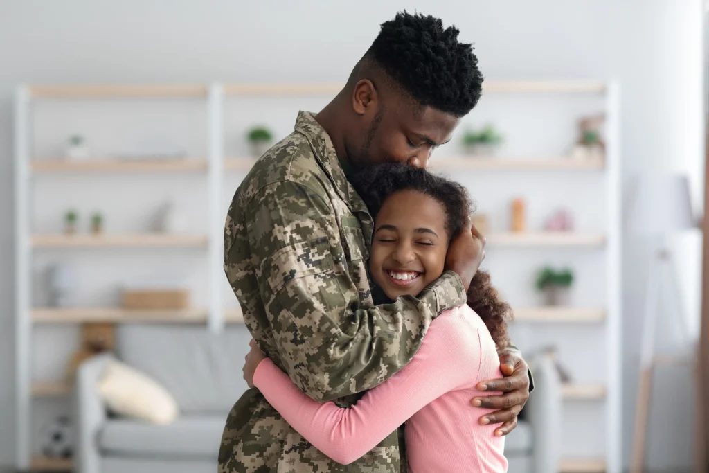 Military dad hugging his daughter.