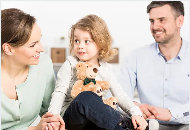 Two parents sitting with their daughter.