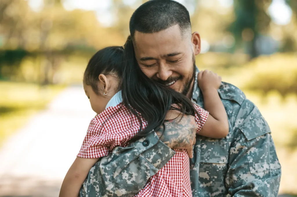 Military father hugging daughter.