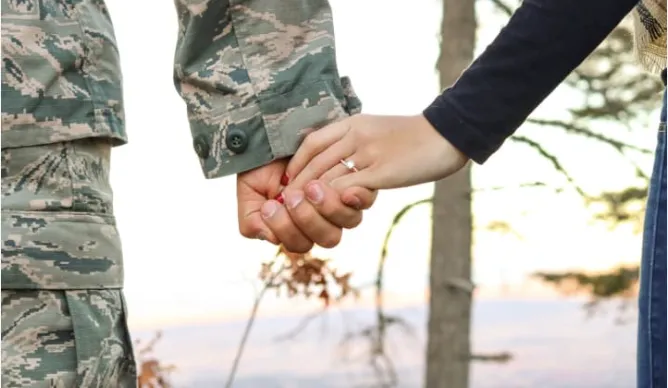 Military couple holding hands.