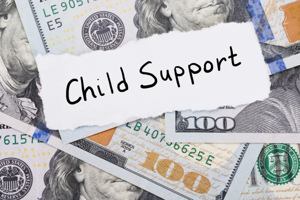 Money with child support written on a piece of paper.