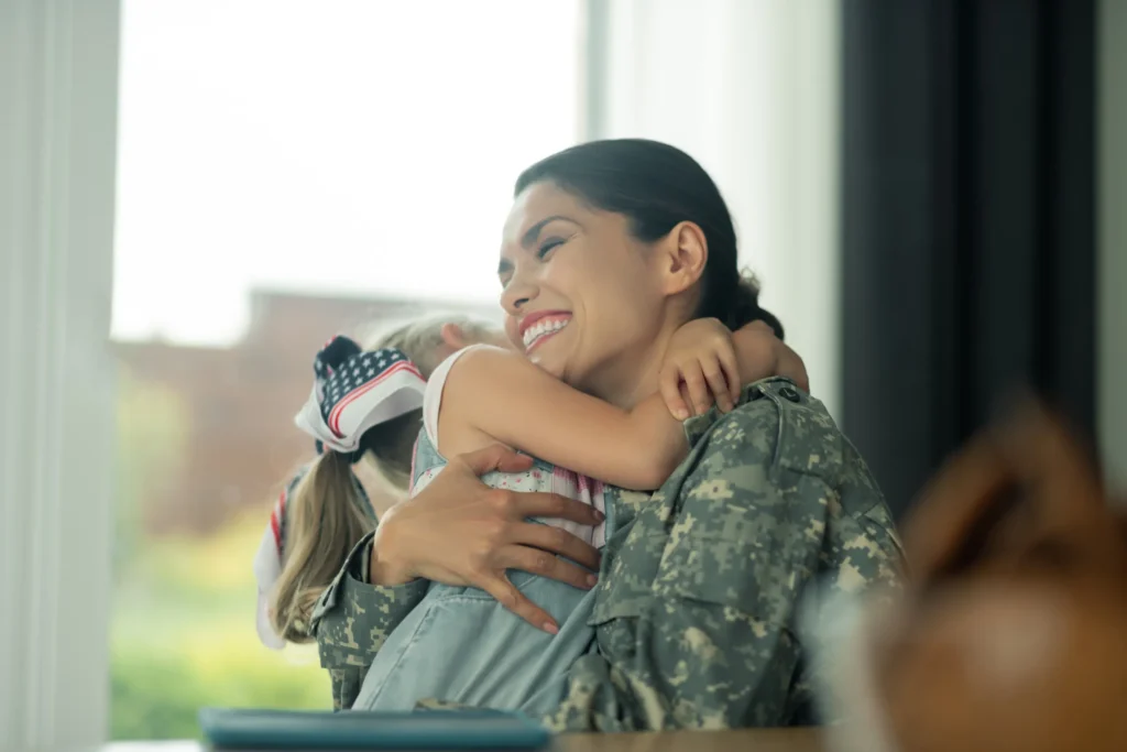 Military mom hugging her daughter.