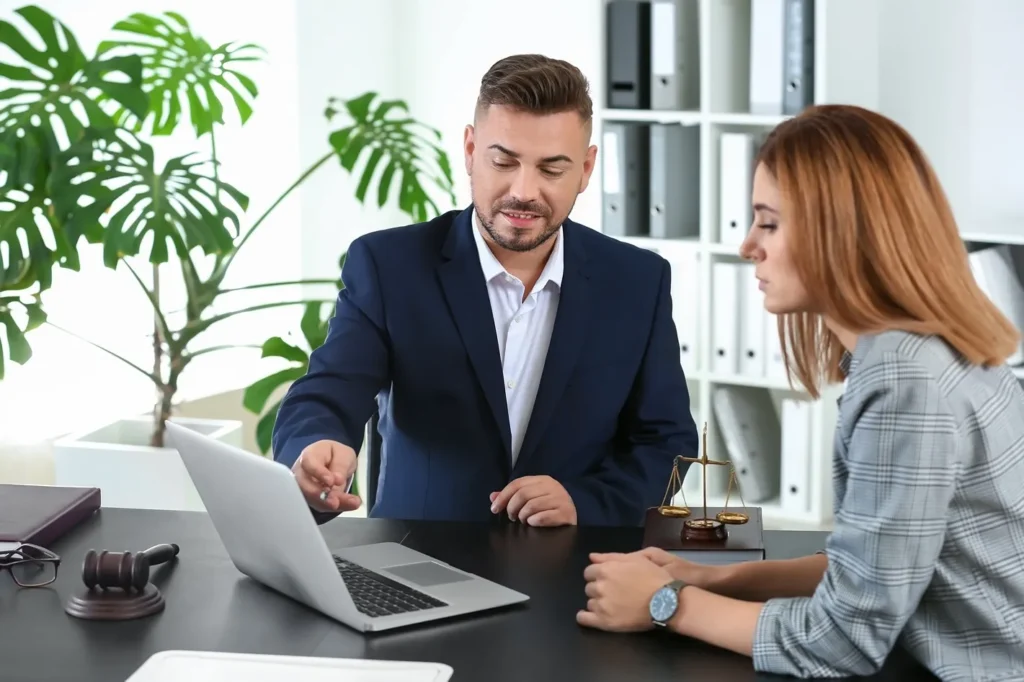 An attorney showing his client something on his computer.