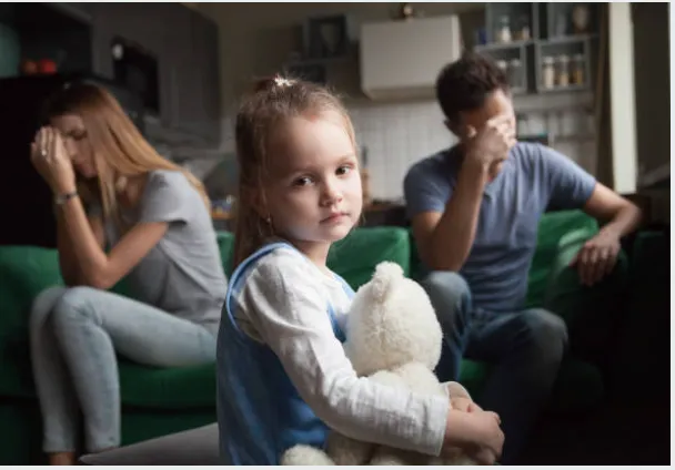 Arguing parents behind daughter.