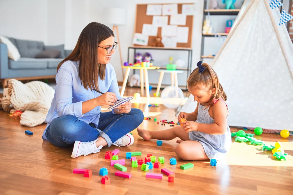 A mother playing on the floor with her child.
