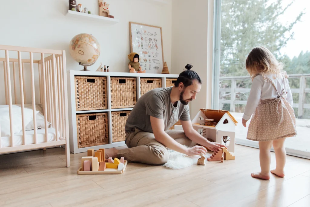 A father playing with his daughter in a playroom.