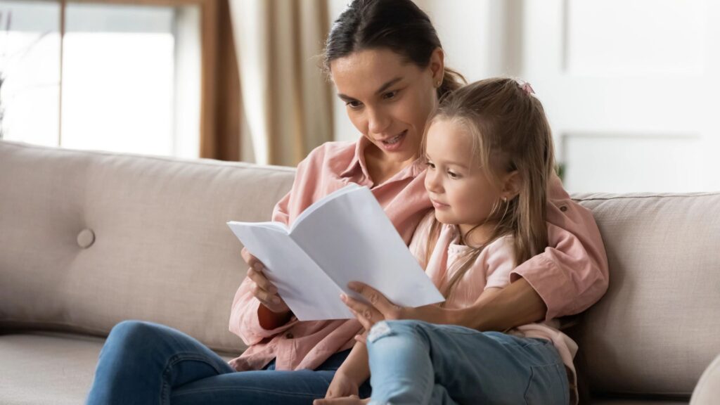 A mother and daughter sitting on a couch.