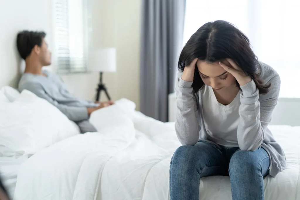 A couple sitting and a woman looking distressed.
