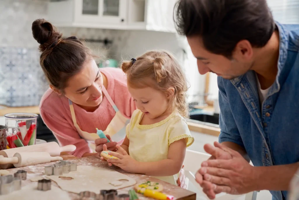 Two parents and child making cookies.